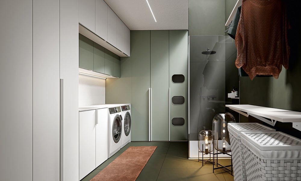 Modern laundry room with integrated washer and dryer, white cabinetry, warm wood panels, concealed storage, and soft under-cabinet lighting in a clean, minimalist design.