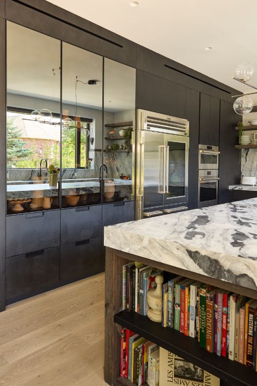 Modern farmhouse kitchen with reclaimed wood island, cement-finish cabinetry, quartzite countertops, and integrated appliances, custom designed by Urban Homes.