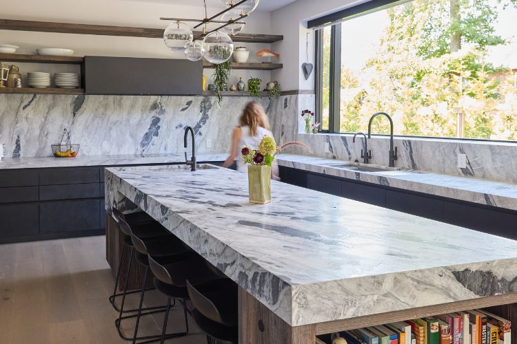 Modern farmhouse kitchen with reclaimed wood island, cement-finish cabinetry, quartzite countertops, and integrated appliances, custom designed by Urban Homes.