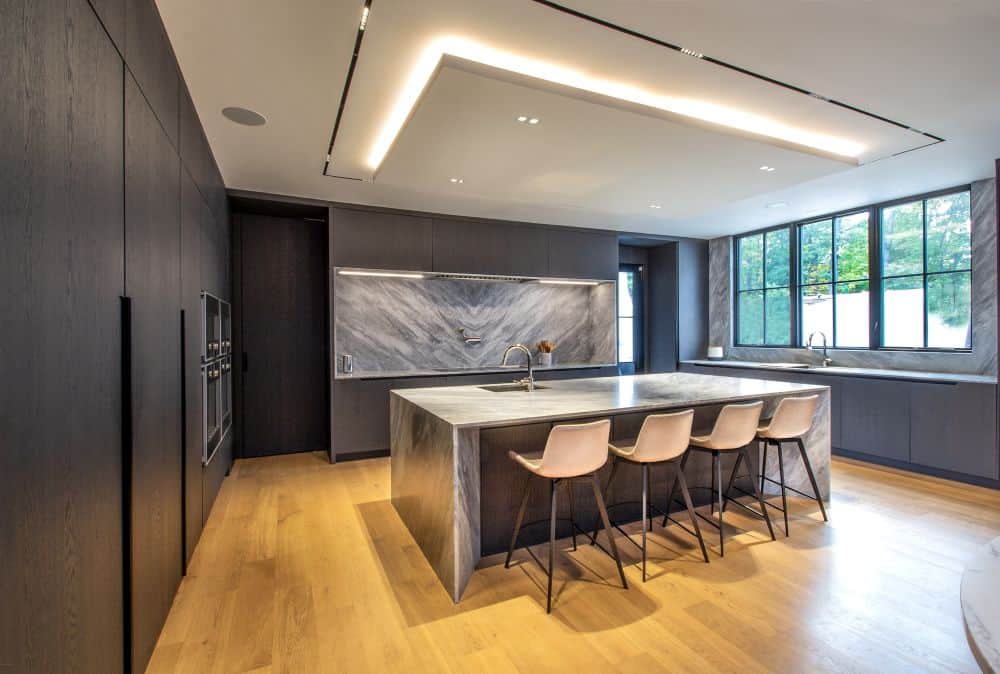 Modern kitchen with sleek gray cabinetry and a large marble island in New Jersey.